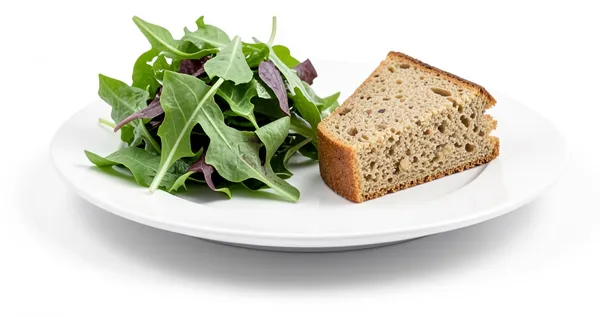 Salad leaves and a slice of seeded bread, a plate trying to be everything at once.