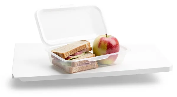 A plastic lunchbox with a sandwich and an apple, eating because you had to.