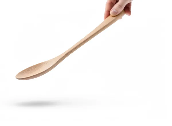 A hand holding out a wooden spoon to taste, mid-cook.