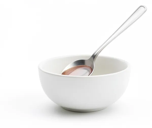 A spoon in a small bowl, tasting again after the change.